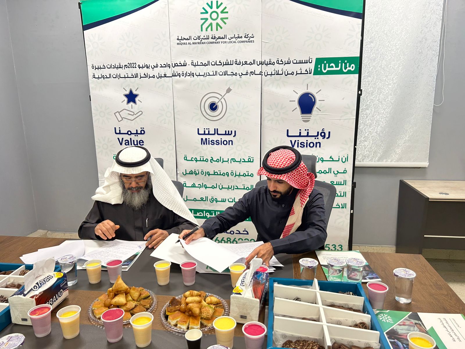 صورة لأحد أعضاء الجمعية في توقيع الأتفاق مع مركز قياس